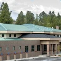 High angle of a building front with a green steel roofing material installation.